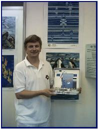 Pascal with his prize in front of child painting awarded